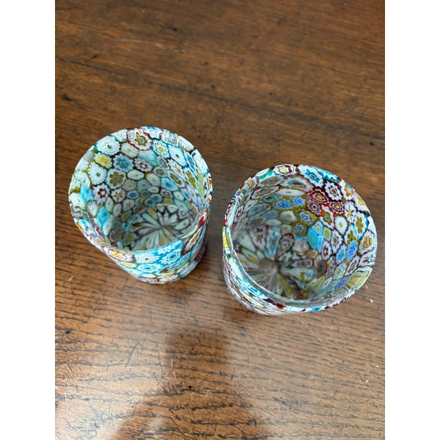 A stunning, vibrant pair of authentic mid-century Italian Murano art glass tumblers, featuring a dense, colorful mosaic of...