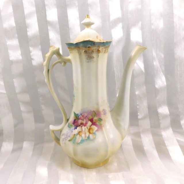 This is aa Reinhold Schlegelmilch (RS Prussia) Chcoolate pot with a matching sugar bowl and creamer. The lid to the sugar...