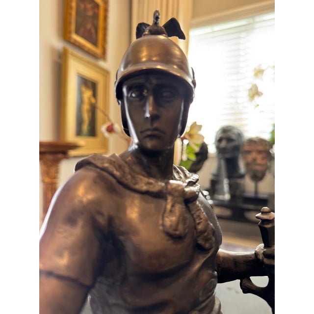 A finely cast bronze sculpture depicting a seated Roman soldier, executed in the Neoclassical tradition and mounted on a...