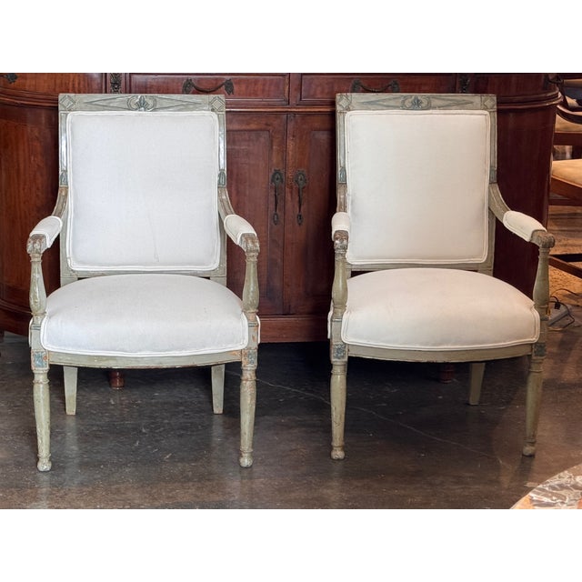 Painted Directoire armchairs with square upholstered backs and seats newly done in a plain white fabric. The top rail is...