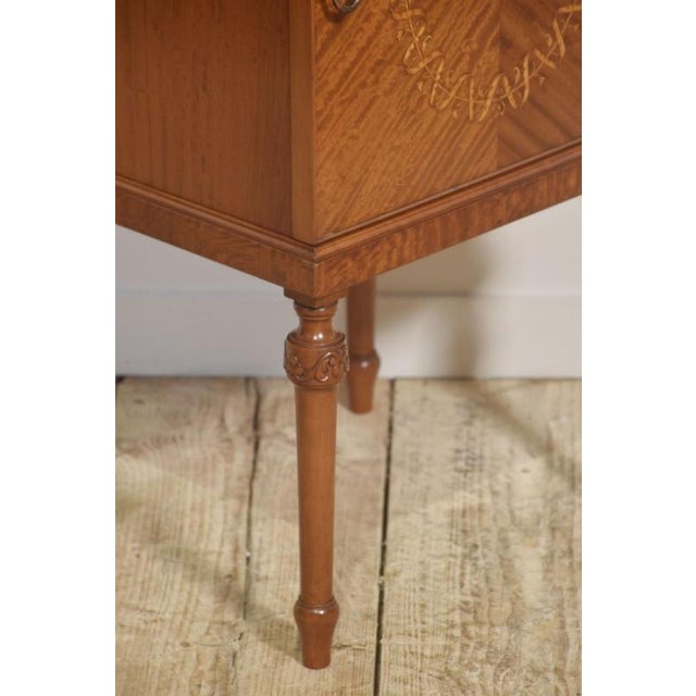 This elegant bedside cabinet is crafted in beautifully figured satinwood, exhibiting the species’ characteristic light...