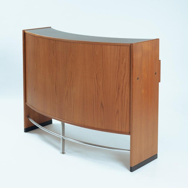 This decorative yet functional liquor bar is executed in beautiful teak. The bar is boomerang shaped with a chromed steel...