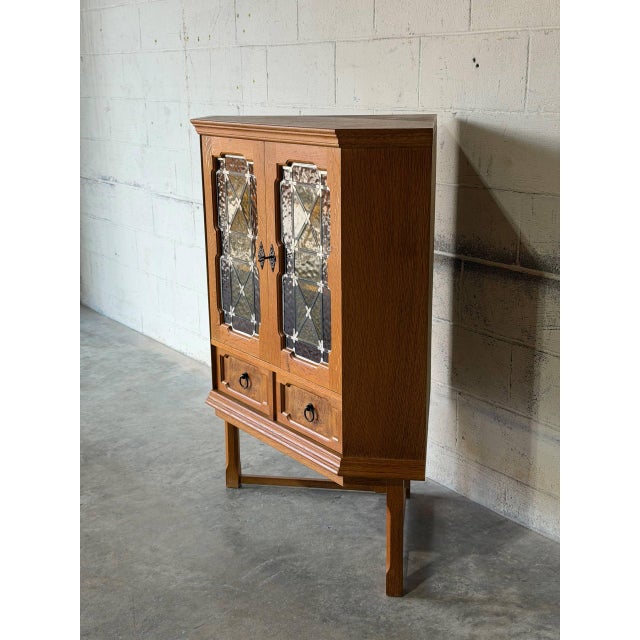 This corner storage cabinet combines geometric glass doors with two lower drawers. Crafted in Denmark, it optimizes corner...