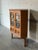 This corner storage cabinet combines geometric glass doors with two lower drawers. Crafted in Denmark, it optimizes corner...