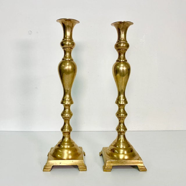 This is a lovely pair of Brass Alter Candlestick Holders. They feature a footed square base and a tall intricate...