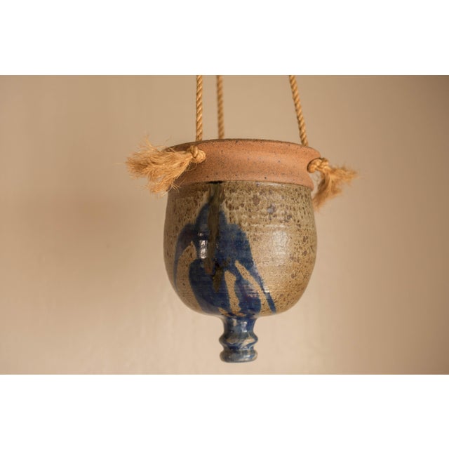 Vintage round ceramic hanging planter pot circa 1970's. Features warm matte neutral tones and a contrasting blue glaze...