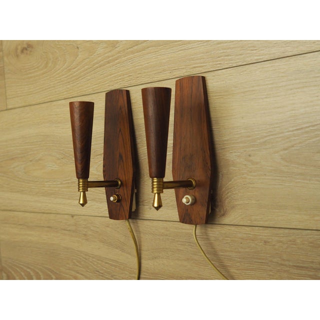 The wall lamps were made in the 1970s, Danish production. Made of rosewood and metal. Set of two. Condition: Lamps in...