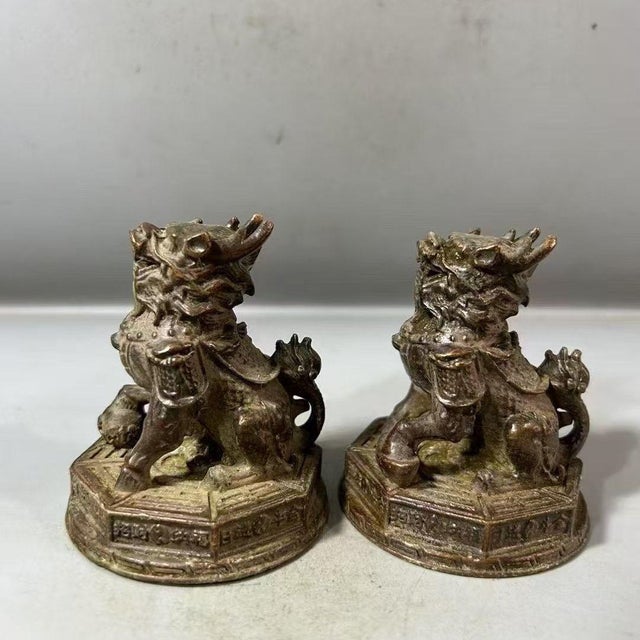 This charming pair of bronze statues depicts Qilin, mythical hooved creatures from traditional folklore, in a seated,...