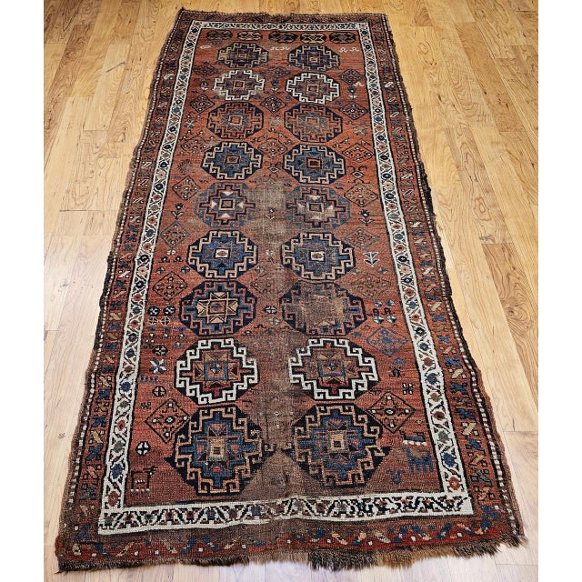 This charming antique Kazak area rug or runner from the Caucasus region, handwoven in the early 20th century, captivates...