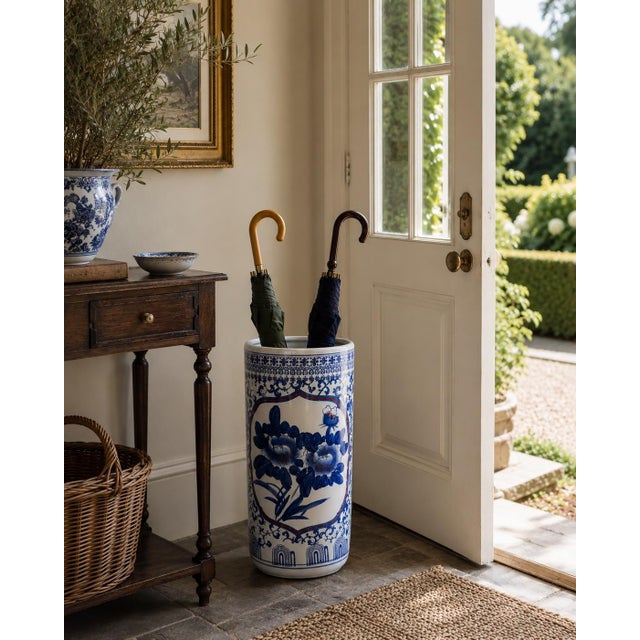 A classic blue and white porcelain umbrella stand in the chinoiserie tradition, featuring finely rendered birds among...