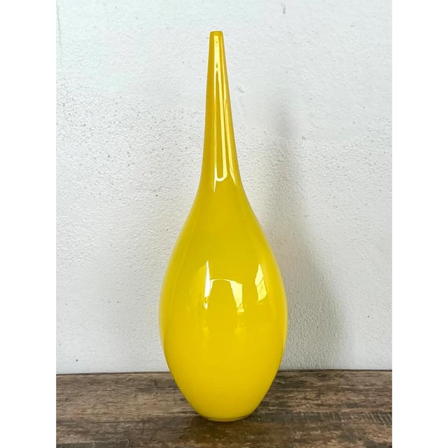 This vintage teardrop vase presents a bold, sculptural silhouette in vivid, sunny yellow glass, its bulbous lower body...