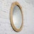 Lovely vintage Coastal or Hollywood Regency style oval wall mirror composed of faux bamboo resin frame with cerused or...