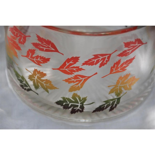 Lovely mid-century modern ice bucket featuring leaves in autumn colors. Made of glass. The leaves are in red, green and...