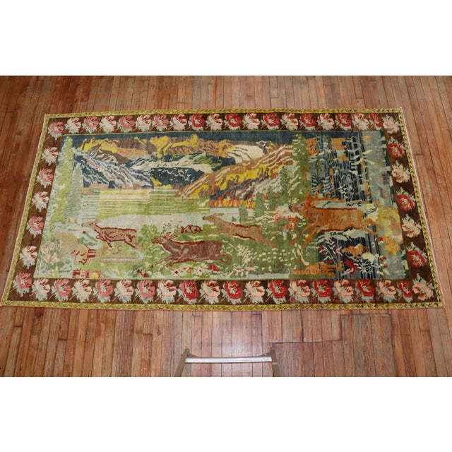 Lovely mid-20th century Russian Karabagh rug with 4 running deers on a scenic background and brown floral border....