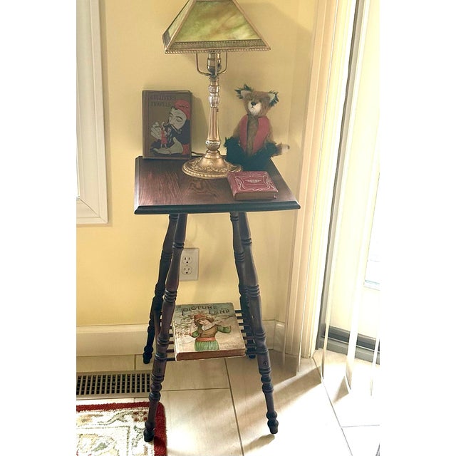 This dark, rich-colored oak, accent table has characteristics of both Victorian and the Edwardian eras. The spool-turned...