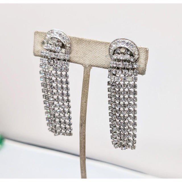 Mid to late 1960s rhodium plated prong set small round clear rhinestone chandelier fringe clip earrings. Marked "NAPIER©"...