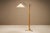 A slender composition of wood, brass and light, this floor lamp captures the restrained character of Swedish Modern...