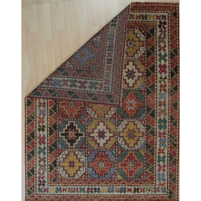 This hand knotted pile rug features a primary brown earth tone and is constructed from wool. Designed in the style of...