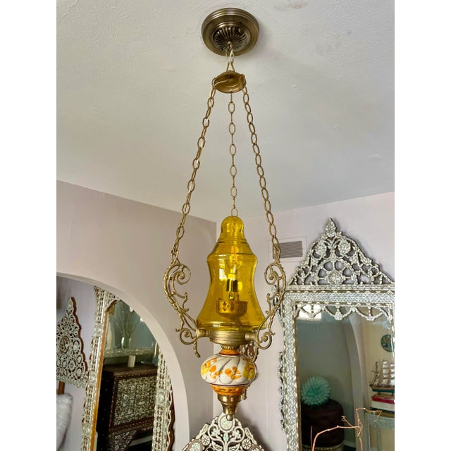 This beautiful triangle brass cast pendant has beautiful golden color piece of handblown glass in the upper part. The...