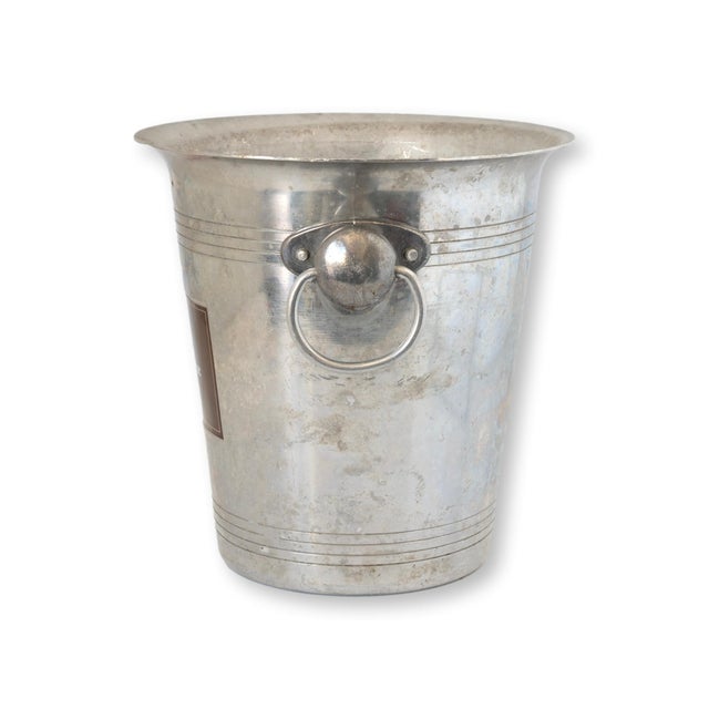 French Canard Duchêne champagne bucket with side ring handles. Logo plaque at center. Wear from use with water and ice....