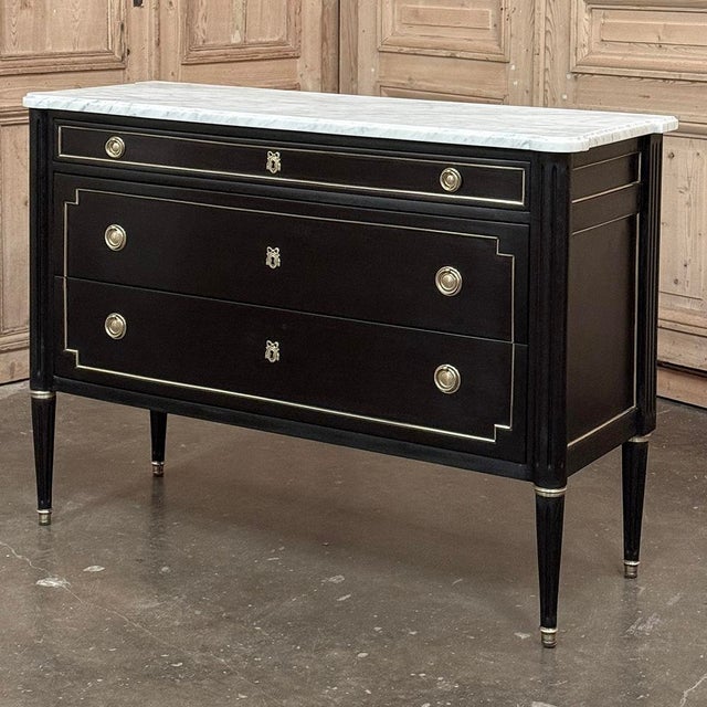 Antique French Louis XVI Mahogany Commode with Carrara Marble is an elegant example of the style! The luxuriously veined...