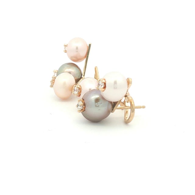 A pair of fun earrings featuring freshwater pearls. The pearls are in shades of gray and white. Each pearl is accented...