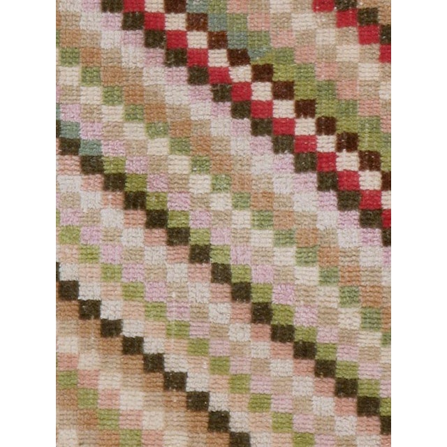 This mid-20th-century Turkish Anatolian throw rug features a lively diagonal checkerboard pattern composed of small...