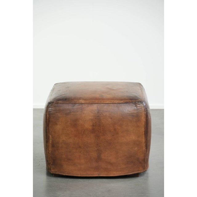 This unique and large sheepskin design ottoman features beautiful colors and a lovely patina. A footstool, also known as a...