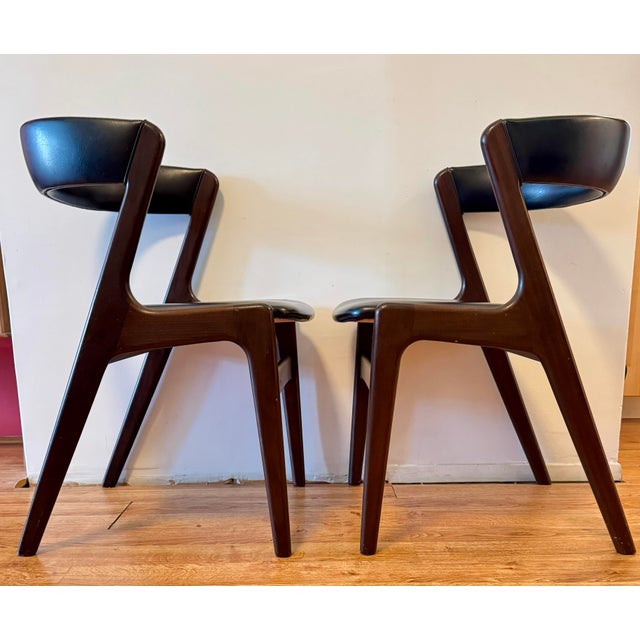 Very good pair of Fire armchairs attributed to Kai Kristiansen in dark brown teak and black leather. Leather in good...