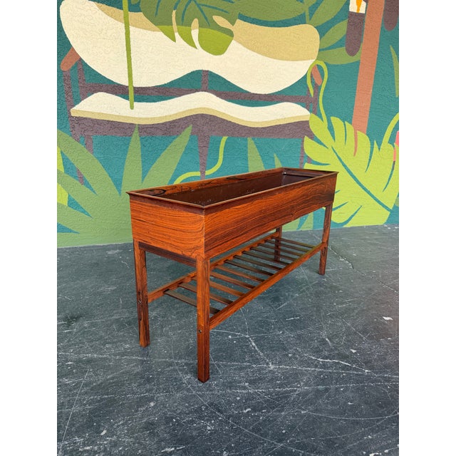 Mid Century Modern Danish Rosewood Planter. Long rosewood planter console with slatted magazine rack below. Lovely grain...