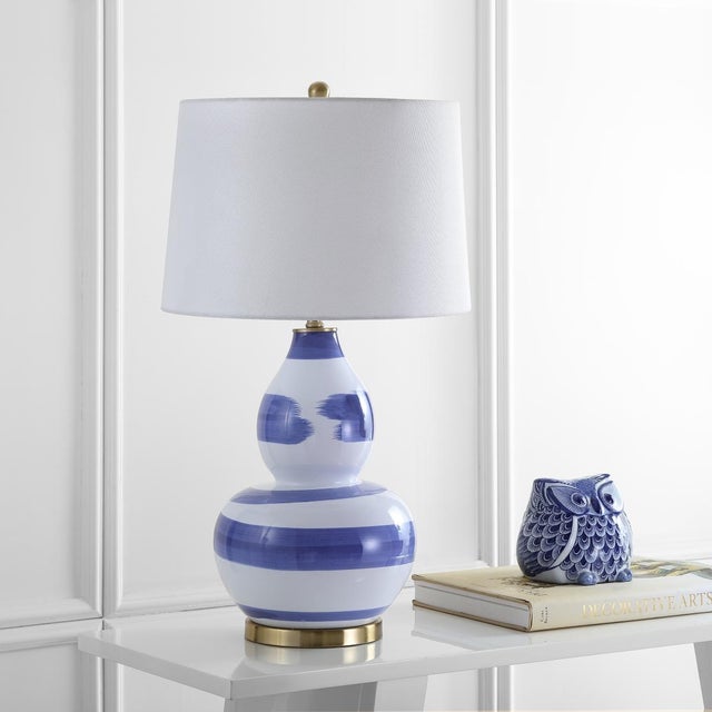 Enhance your living space with the Aileen Table Lamp in brown and gold. This lamp features a ceramic base that exudes...