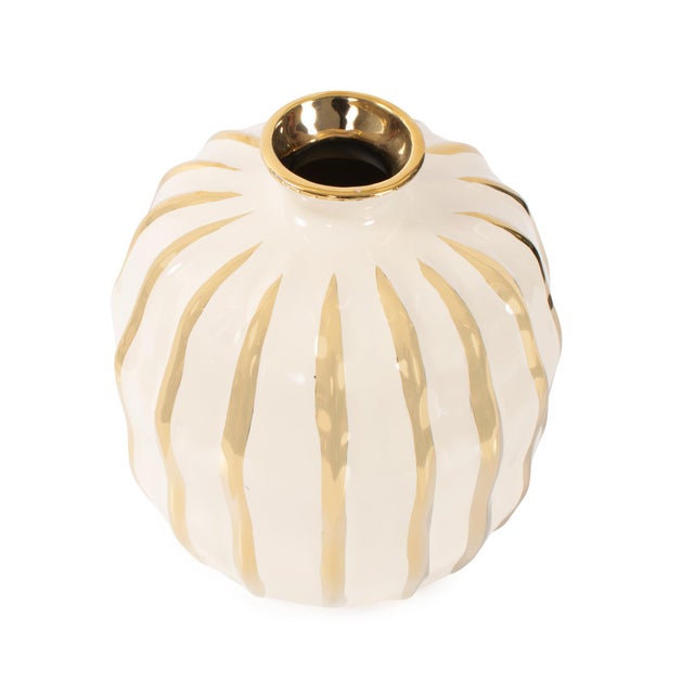 Finished in a smooth cream glaze and detailed with striking metallic gold accents, this vase brings a modern sense of...