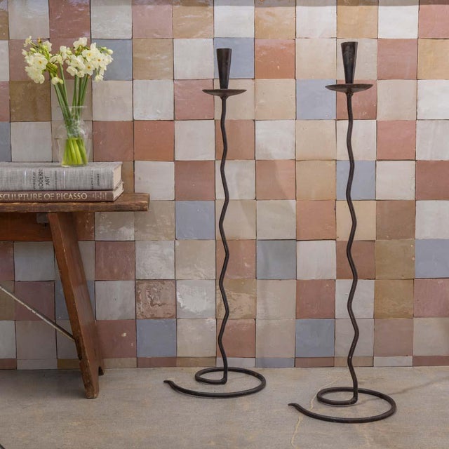 Unique pair of tall iron candlesticks from France, 1950s. Circular drip pan sits on a wavy stem and spiral base. Beautiful...