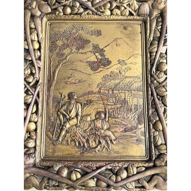 Antique metal relief plaque, likely made of bronze and copper, featuring a central scene framed by an ornate border with...