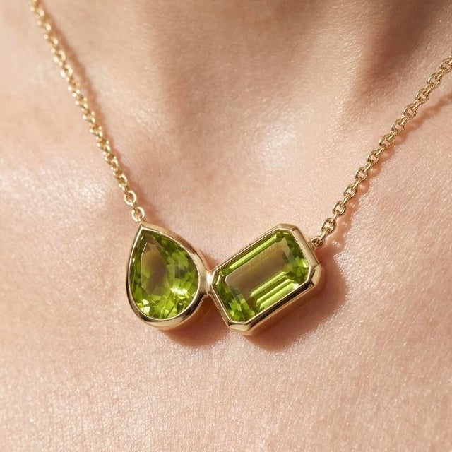 This exquisite necklace features a radiant pairing of olive-green Peridot gemstones, prized for their luminous brilliance...