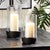 Architectural in design, a simple glass form fits into a grooved metal base. Its warm weathered patina makes it perfect...