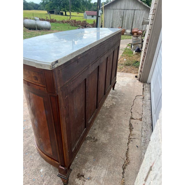 19th Century Louis XVI Demi-Lune Buffet crafted in richly figured walnut with elegant bookmatched veneer panels and a...
