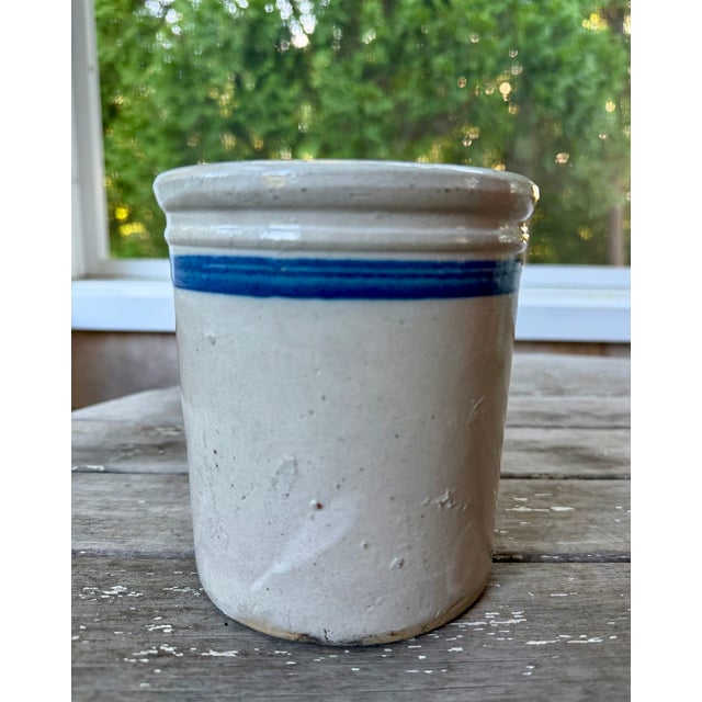 Antique stoneware advertising crock with blue stripe and stenciled round stamp in blue ink advertising a general store....