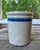 Antique stoneware advertising crock with blue stripe and stenciled round stamp in blue ink advertising a general store....