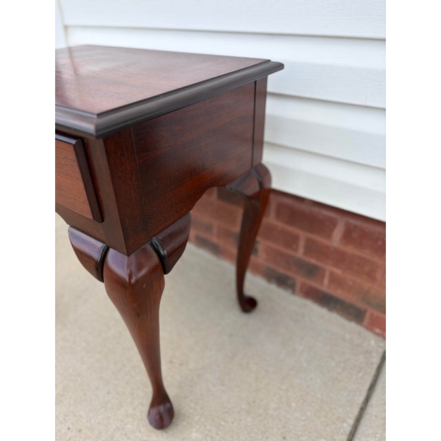 Elegant vintage Queen Anne-style side or lamp table featuring graceful cabriole legs, pad feet, a shaped apron, and a...