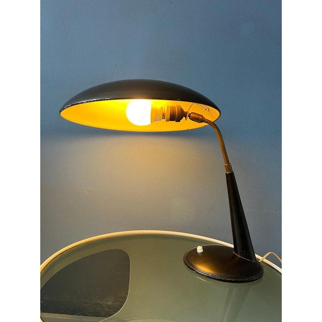 Black Christian Dell table lamp for Kaiser Leuchten. The lamp is made out of metal. The lamps has a switch on the base. It...