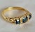 A striking vintage ring crafted in rich yellow gold and set with three deep blue faceted sapphires accented by small...
