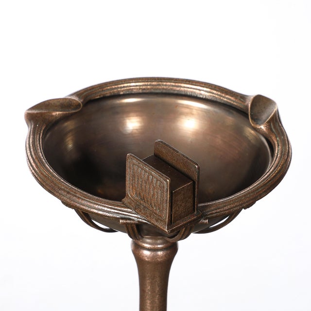 This elegant smoking stand exemplifies Tiffany Studios’ unparalleled craftsmanship, blending function with timeless Art...