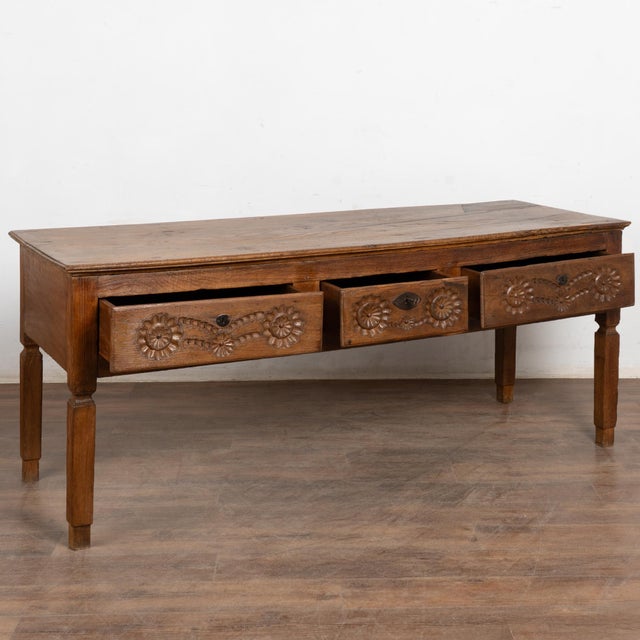 17th-century Portuguese dark oak console table with three carved drawers and tall legs. Handsome carvings adorn drawer...