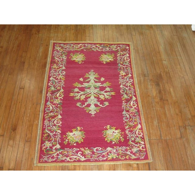 Antique Turkish Ghiordes rug with an enchanting floral palette on a raspberry field circa 1900. Measures: 3'9" x 6'.