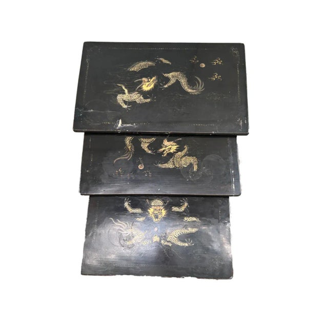 Set of three 19th C. English Regency black painted wood chinoiserie nesting tables with gilding, featuring mythical...