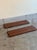 Danish Mid-Century Modern floating shelves crafted in richly grained rosewood with original brass wire wall brackets....