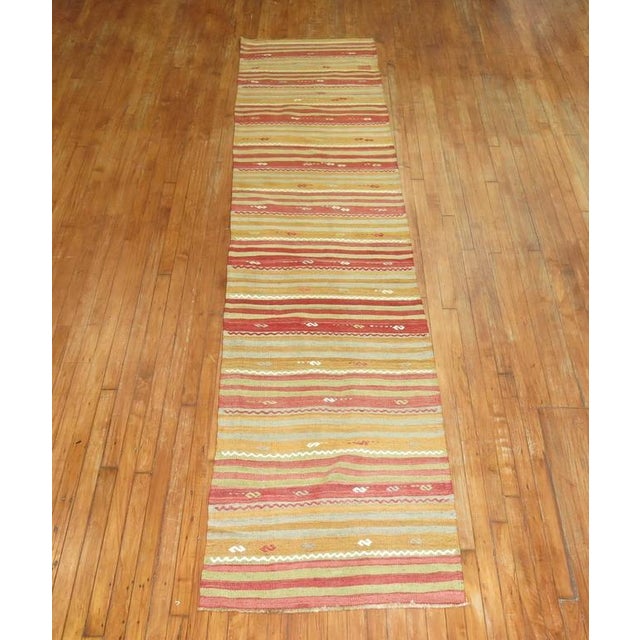 A mid century Turkish Kilim runner from the mid-20th century. Measures: 2'8" x 12'1". Kilims, primarily refer to a type of...