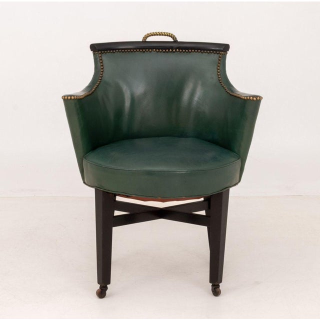 Regency Style Green Vinyl Upholstered Ebonized Arm Chair, with riveted brass detail and rope twist top handle, atop...