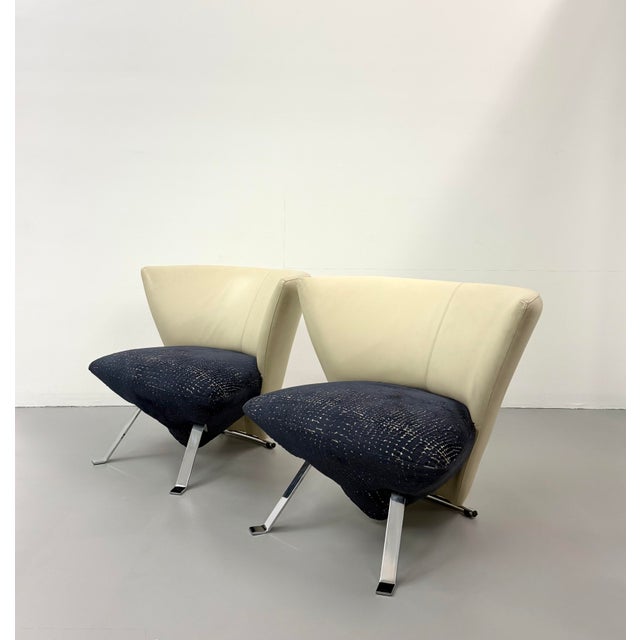 A striking pair of JADA lounge chairs showcasing a sculptural silhouette with gently flared barrel backs, polished chrome...